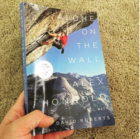 Alex Honnold taking a picture of his book for promotion post.